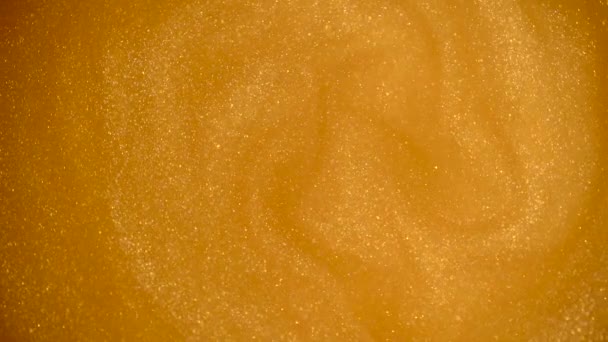 Gold glitter abstract background. Shiny liquid gold paint flows slowly onto the surface. Holidays, new year, fashion, abstract art concept video — Stock Video