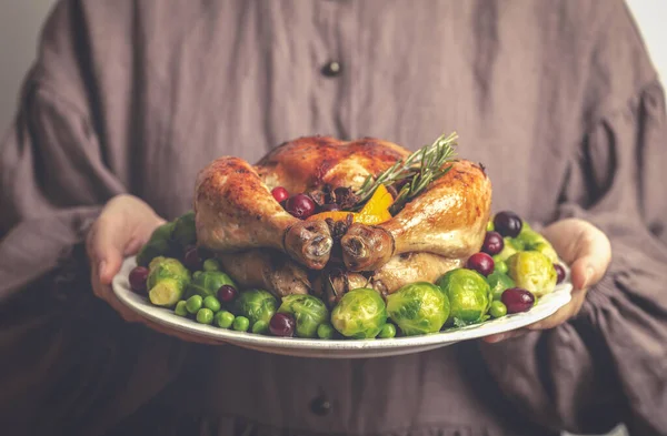 感謝祭の夕食のための七面鳥または鶏。古典的なアメリカのドレスで女性の手に揚げ鶏のプレート。感謝祭と秋の季節の食のコンセプト. — ストック写真