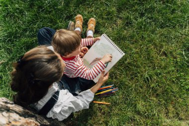 Anne ve yeni yürümeye başlayan çocuk bir yaz parkında birlikte çizim yapıyorlar. Ebeveynlik ve Çocukluk Gelişimi Konsepti. Yüksek kalite fotoğraf