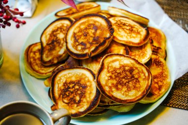 Pofuduk Krep Oladyi tabakta. Yumuşak Rus Doğu Avrupa krepleri Oladyi, konforlu yemek ve ev yapımı kahvaltıyı vurgulayarak açık mavi bir tabakta servis etti.