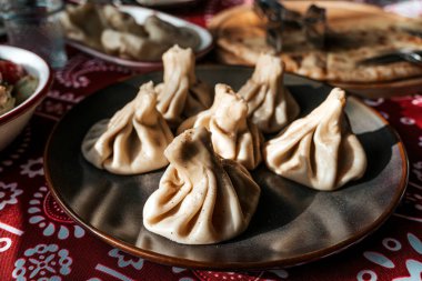 Geleneksel Gürcistan Khinkali Mantı Tabağı. Khinkali Gürcistan 'ın kara biberle kaplanmış et köfteleri, Gürcistan mutfağının zengin mutfak geleneğini vurgulayarak koyu tabakta servis ediliyor..