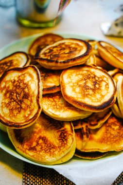 Pofuduk Krep Oladyi tabakta. Yumuşak Rus Doğu Avrupa krepleri Oladyi, konforlu yemek ve ev yapımı kahvaltıyı vurgulayarak açık mavi bir tabakta servis etti.