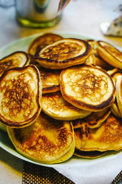 Pofuduk Krep Oladyi tabakta. Yumuşak Rus Doğu Avrupa krepleri Oladyi, konforlu yemek ve ev yapımı kahvaltıyı vurgulayarak açık mavi bir tabakta servis etti.