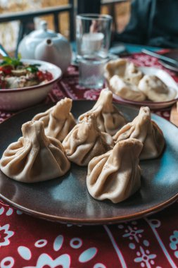 Geleneksel Gürcistan Khinkali Mantı Tabağı. Khinkali Gürcistan 'ın kara biberle kaplanmış et köfteleri, Gürcistan mutfağının zengin mutfak geleneğini vurgulayarak koyu tabakta servis ediliyor..