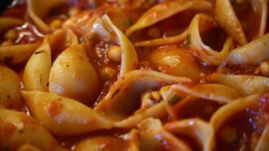 Zengin domates soslu ve nohutlu Conchiglie kabuklu makarna. Yüksek kaliteli FullHD görüntüler