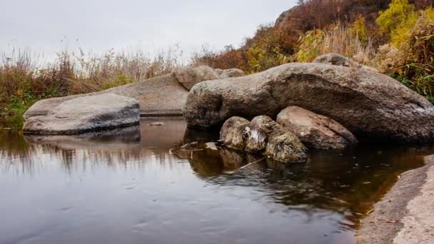 Őszi fák és nagy kősziklák. Egy vízesés az őszi patakban, lehullott levelekkel. Víz folyik a kövek körül a folyóban. Aktovszkij-kanyon, Ukrajna. — Stock videók