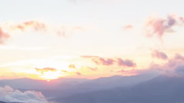 Ρομαντικό πολύχρωμο ηλιοβασίλεμα στα βουνά. Ο ήλιος ανατέλλει, μπλε και πορτοκαλί σύννεφα ρέουν στον ουρανό. Μαγευτικό υπέροχο τοπίο. Χρονοδιαγράμματα αργής κίνησης 4K βίντεο. — Αρχείο Βίντεο