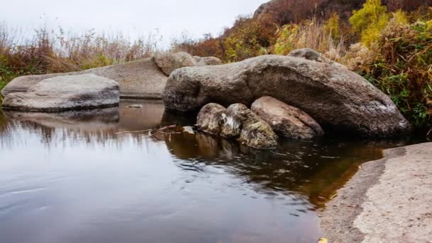 나무늘보와 주위에 있는 커다란 돌덩어리들 입니다. 가을에는 낙엽이 떨어지는 급류가 불어온다. 강에 있는 돌들 주위로 물이 흐릅니다. 우크라이나,아크 토브 스키 협곡. — 비디오