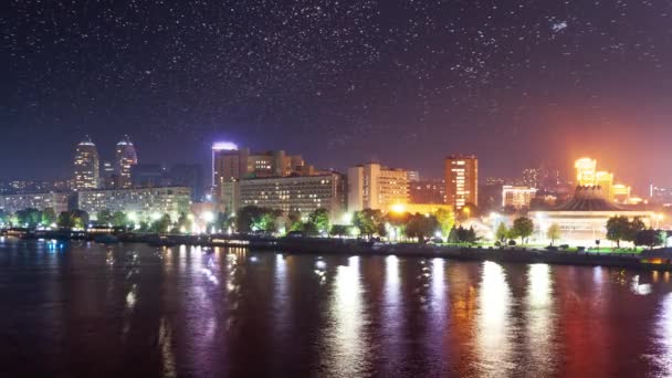 Paisagem urbana abstrata com arranha-céus modernos de edifícios altos e luzes da cidade refletidas na superfície de água espelhada de rio calmo ou lago na noite escura. Sem pessoas, a cronologia. — Vídeo de Stock