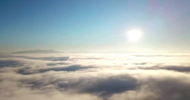 Dağlarda görkemli bir gündoğumu görüntüsü. Dağlar arasındaki vadi sisle kaplıdır ve yükselen güneşin sıcak ışınlarıyla aydınlanır. Dağlar doğal ormanlarla kaplı..