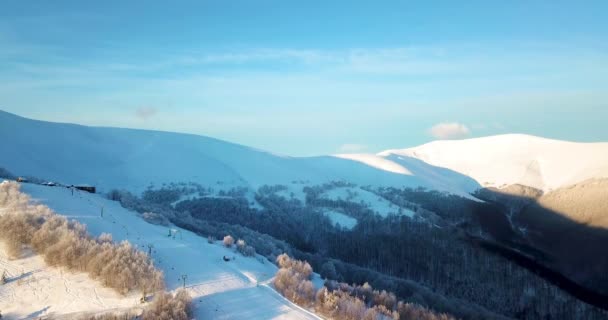 Foto aérea de majestuoso amanecer en las montañas. Valle entre las montañas está cubierto de niebla y está iluminado por los cálidos rayos del sol naciente. Montañas cubiertas de bosque natural. — Vídeos de Stock