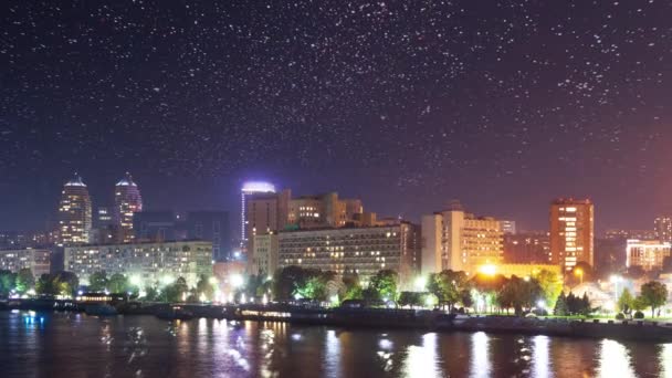 Paisaje urbano abstracto con edificios modernos de gran altura rascacielos y luces de la ciudad reflejadas en la superficie del espejo de agua del tranquilo río o lago en la noche oscura. Sin gente, timelapse. — Vídeos de Stock