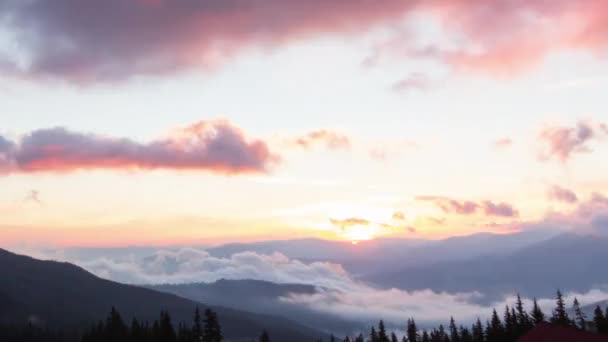 Romantyczny kolorowy wschód słońca w górach. Słońce wschodzi, niebieskie i pomarańczowe chmury płyną po niebie. Wspaniały krajobraz. Ramy czasowe zwolnień 4K materiał filmowy. — Wideo stockowe