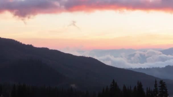 Romántico amanecer colorido en las montañas. El sol sube, las nubes azules y anaranjadas fluyen en el cielo. Majestuoso paisaje maravilloso. Timelaps de cámara lenta Imágenes 4K. — Vídeos de Stock