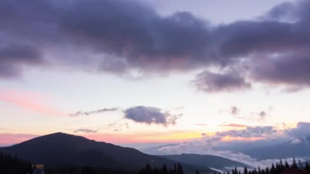 Ρομαντικό πολύχρωμο ηλιοβασίλεμα στα βουνά. Ο ήλιος ανατέλλει, μπλε και πορτοκαλί σύννεφα ρέουν στον ουρανό. Μαγευτικό υπέροχο τοπίο. Χρονοδιαγράμματα αργής κίνησης 4K βίντεο. — Αρχείο Βίντεο
