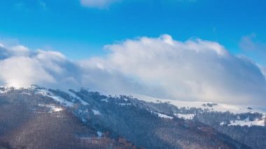 Yüksek Dağlar Tepeleri 'nin Manzaralı Hava Görüntüsü. Güneşli Kış Günü 'nde destansı manzara. Blue Sky, Fog ve Snow 'la hızlandırılmış video. Ukrayna 'daki Karpat Dağı' nın 4K Arka plan Çekimi