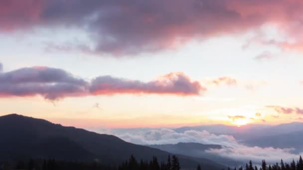 Romántico amanecer colorido en las montañas. El sol sube, las nubes azules y anaranjadas fluyen en el cielo. Majestuoso paisaje maravilloso. Timelaps de cámara lenta Imágenes 4K. — Vídeos de Stock