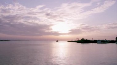 Sunset boat silhouette at Olhão, capital of Ria Formosa wetlands natural conservation region landscape, Algarve, southern Portugal.