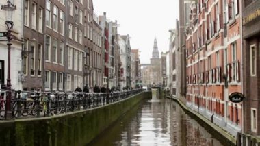 Sabah kış Unesco Dünya Mirası şehir kanallar (Oudezijds Kolk) Amsterdam whit Oude Kilisesi arka planda biri Hollanda görüntüleyin.