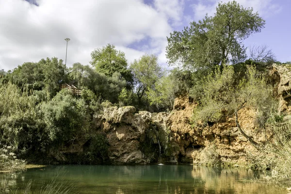 Hermosa cascada con un pequeño lago en la famosa zona de picnic natural hidenn, llamado Pego do inferno (Hells Pond) cerca de Tavira, Algarve . —  Fotos de Stock