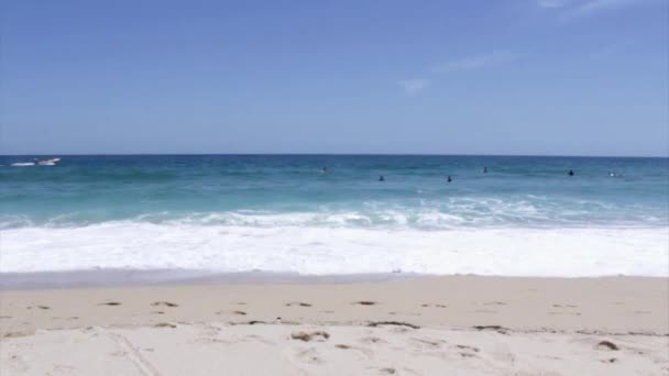 Vue sur l'océan et les personnes surfant sur l'île de Tavira, Algarve, Portugal . — Video