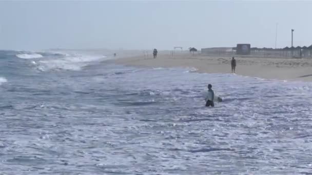Uitzicht op de Oceaan en mensen surfen in Tavira eiland, Algarve, Portugal. — Stockvideo