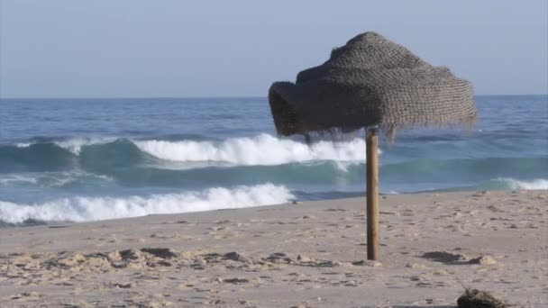 Sonnenschirm im Sand am Strand und Blick auf den Atlantik von der Insel Tavira, Algarve. — Stockvideo