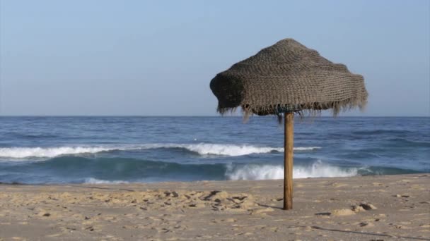 Sonnenschirm im Sand am Strand und Blick auf den Atlantik von der Insel Tavira, Algarve. — Stockvideo