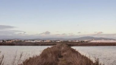 Algarve hedefinin Olhao Waterfront Ria Formosa sulak doğal koruma Parkı, bulutlu bir akşam ön planda etkin olmayan tuz bataklığı üretim pan Pan Timelapse görünümünde 360.