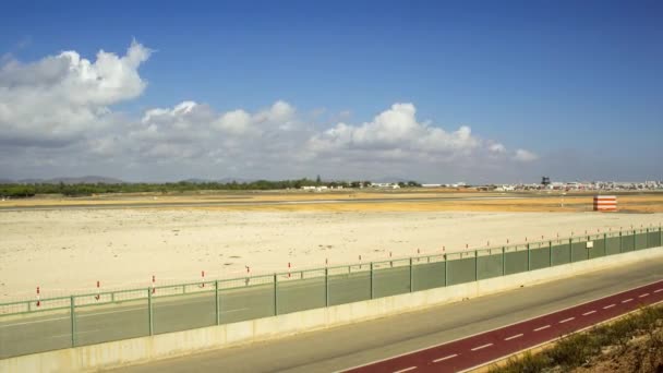 アルガルヴェ地方の有名な地にある曇り空の午後のファロ空港トラックの時間経過表示をパンします。. — ストック動画