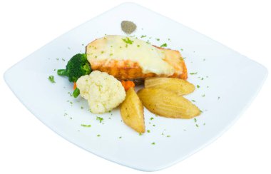 Tahta masada patates ve sebzeli kızarmış somon bifteği.