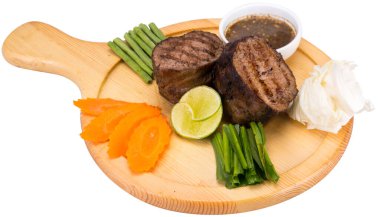 Tahta tabakta iştah açıcı kazık. Biber soslu ızgara et.