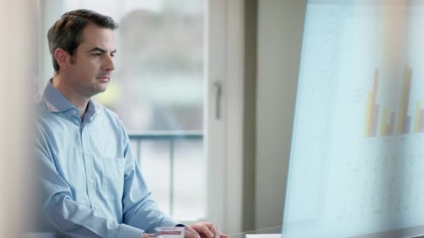 Hombre de negocios mirando gráficos en la pantalla — Vídeos de Stock