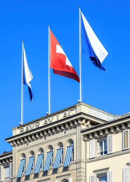 Flags on the top of the Baur au Lac Hotel building — Stock Photo, Image