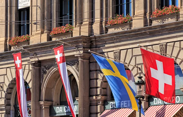 Vlajky na fasádě budovy Curych hlavní železniční stanice — Stock fotografie