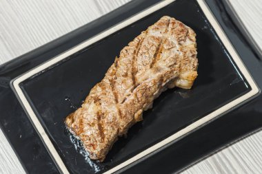 Siyah bir tabakta biftek. Üst görünüm