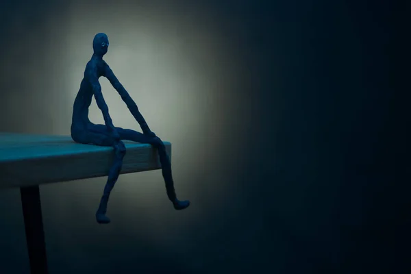 Imagem Homem Sentado Beira Luz Azul Noite Sobre Fundo Preto — Fotografia de Stock