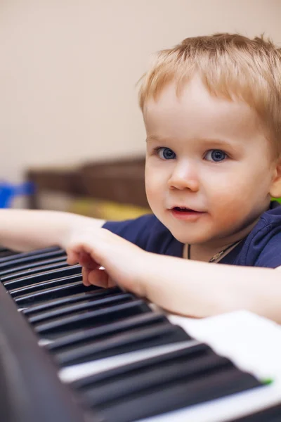 Niño pequeño disfruta tocando el piano eléctrico (sintetizador ) — Foto de Stock
