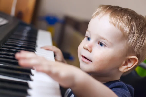 Niño pequeño disfruta tocando el piano eléctrico — Foto de Stock