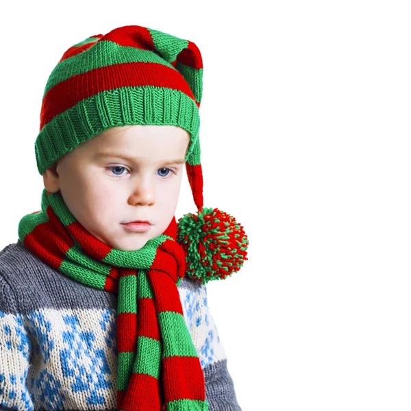 Christmas boy in knitted cloths looks down sad — Stock Photo, Image