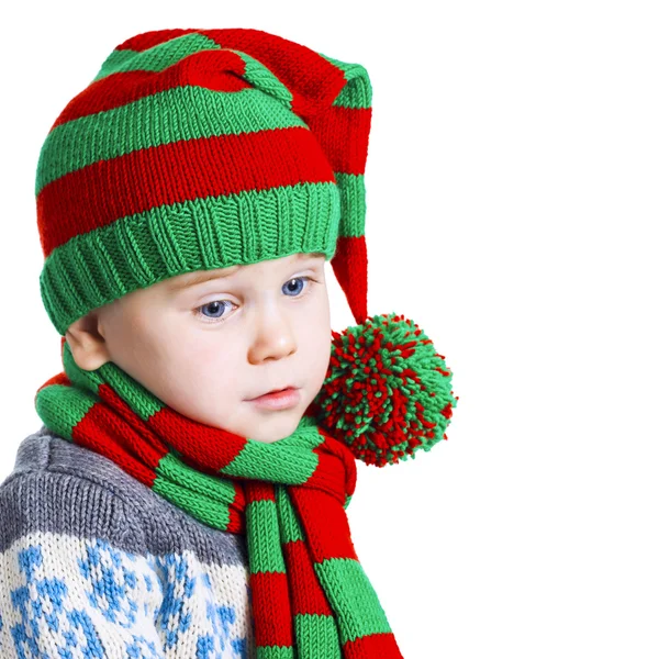 Christmas boy in knitted cloths looks down sad — Stock Photo, Image