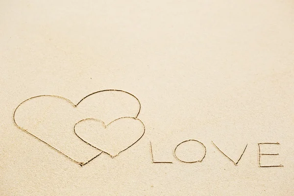 Inschrift der Liebe auf nassem gelben Sand am Strand geschrieben — Stockfoto