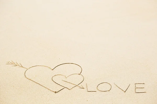 Inschrift der Liebe auf nassem gelben Sand am Strand — Stockfoto