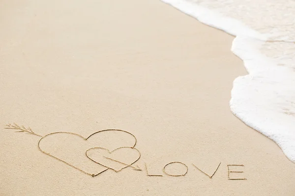 Inscriptie van liefde op natte gele strand zand — Stockfoto