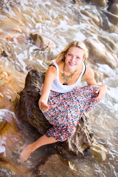 Blonde vrouw die zich voordeed op de rotsachtige kust — Stockfoto