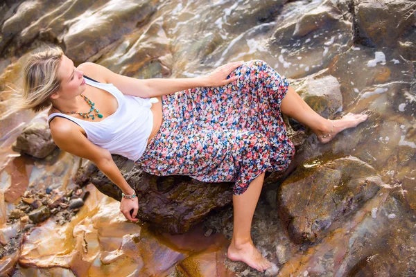 Blondýnka pózuje v kamenné moře pobřeží — Stock fotografie