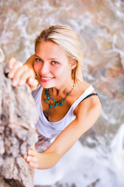 Blonde vrouw die zich voordeed op de rotsachtige kust — Stockfoto