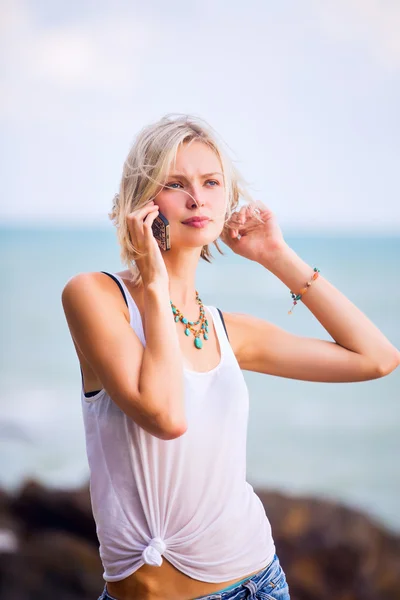 Mulher falando ao telefone na costa do mar . — Fotografia de Stock