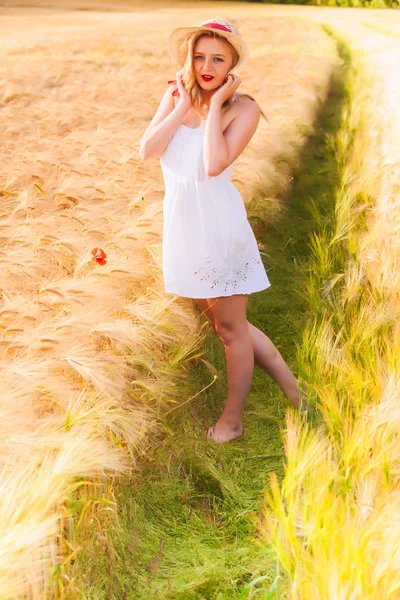 Eenzame mooie jonge blonde meisje in witte jurk met stro hoed — Stockfoto