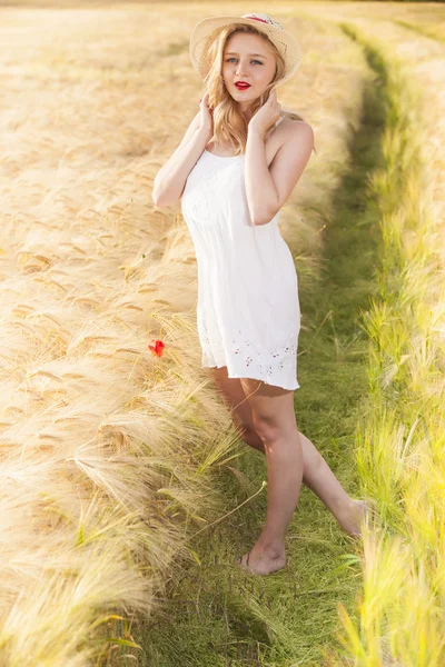Eenzame mooie jonge blonde meisje in witte jurk met stro hoed — Stockfoto